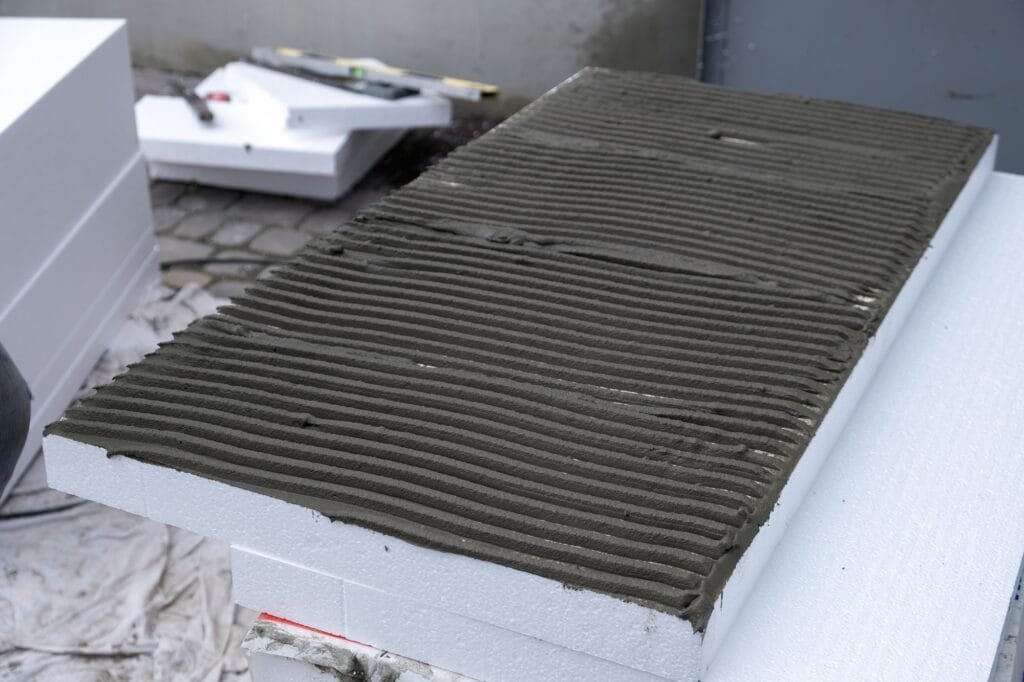 Instalación de planchas aislantes de espuma de poliestireno en la pared de la fachada de la casa para protección térmica