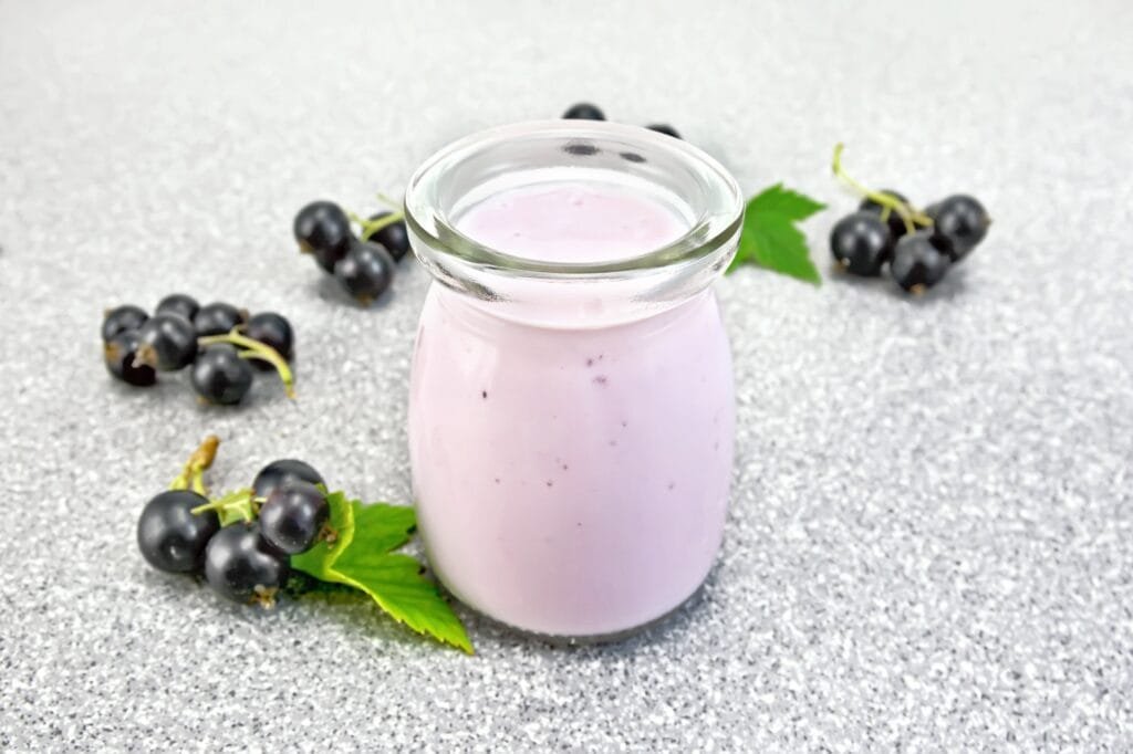 Milk cocktail with black currant on granite table