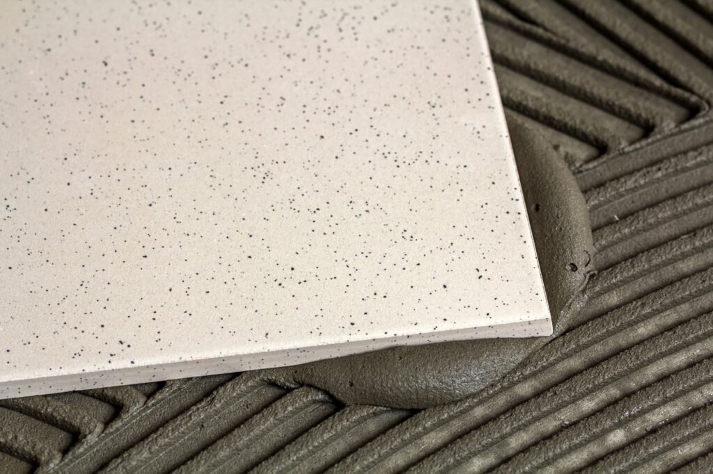 Carreaux de céramique et outils pour carreleur. Pose de carreaux de sol. Amélioration de l'habitat, rénovation