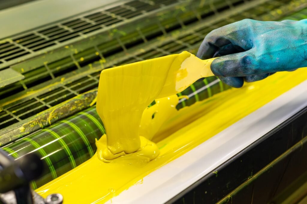 Ouvrier d'imprimerie chargeant de l'encre dans une machine